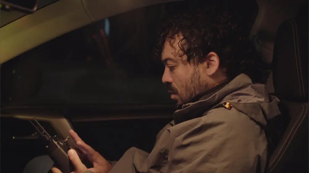 Jose maneja el control del dron dentro del auto de noche