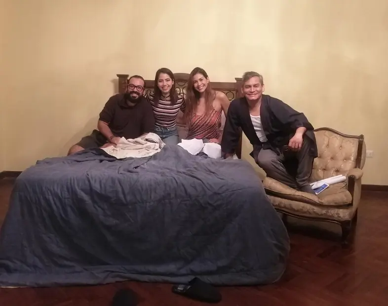 Jose Adrianzen con Matilde Carrión y el reparto sobre la cama del set