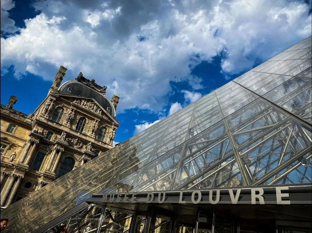 Pirámide del Museo del Louvre contra las nubes