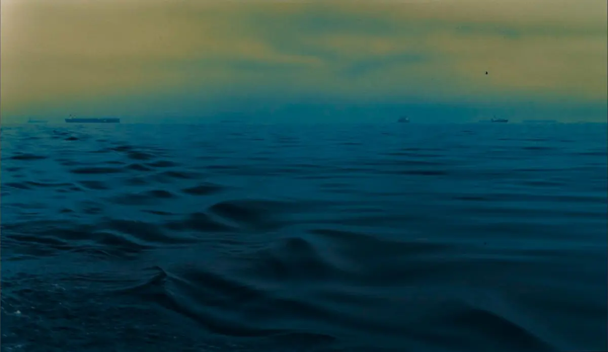 Mar abierto con barcos en el horizonte al amanecer