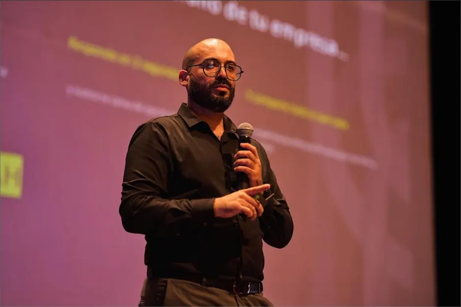 Jose Adrianzen habla con micrófono durante una presentación