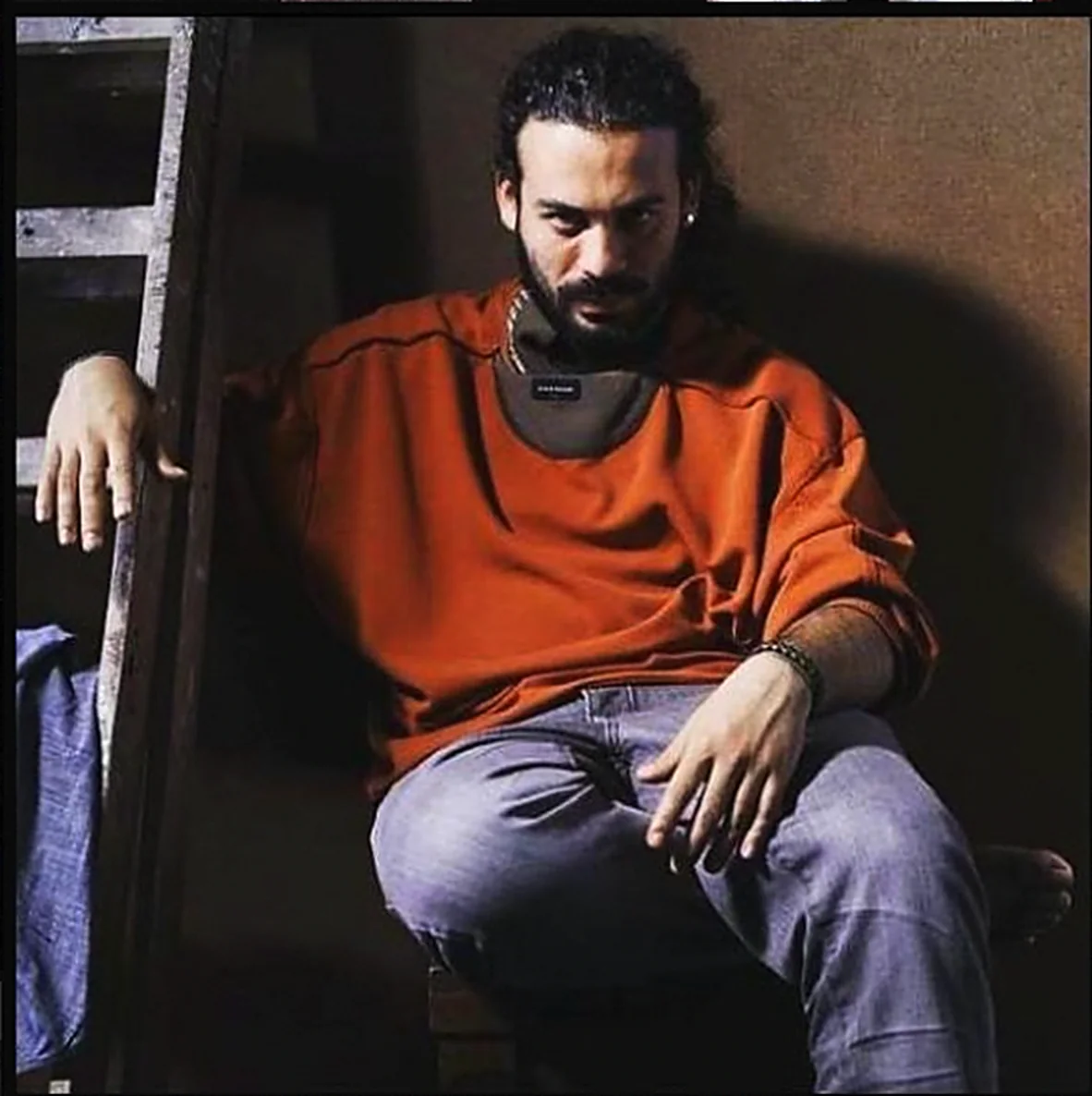Jose Adrianzen sentado junto a una escalera de madera